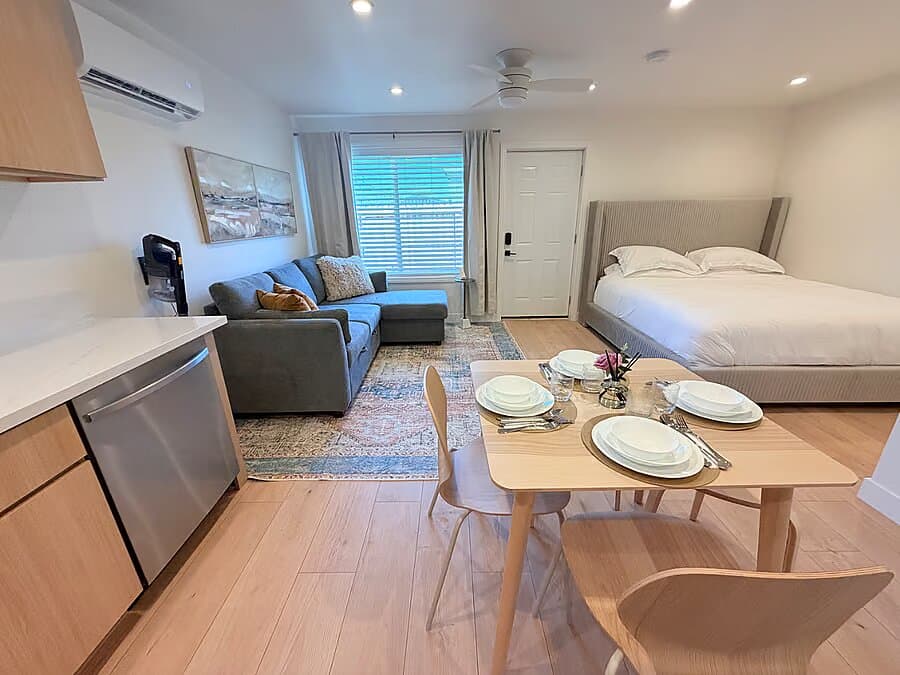 Open studio showing the king bed, sofa, dining table, and kitchen at the Anaheim ADU